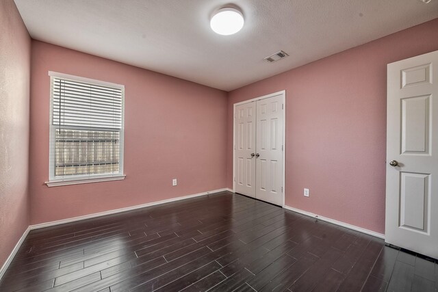 2444 Horseback Trl, Fort Worth, TX 76177 - unfurnished bedroom featuring baseboards, dark wood-style flooring, and a closet