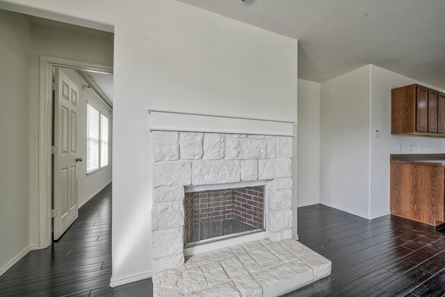 2444 Horseback Trl, Fort Worth, TX 76177 - unfurnished living room with a stone fireplace, dark wood finished floors, and baseboards