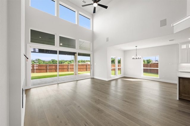 7127 Seagrove Ct, Grand Prairie, TX 75054 - unfurnished living room featuring a chandelier, a ceiling fan, a towering ceiling, dark wood-style flooring, and healthy amount of natural light