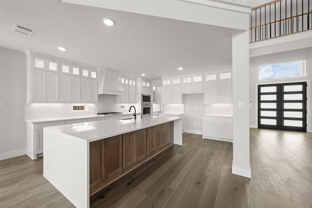 7127 Seagrove Ct, Grand Prairie, TX 75054 - kitchen with custom exhaust hood, stainless steel appliances, dark wood-type flooring, a spacious island, and recessed lighting