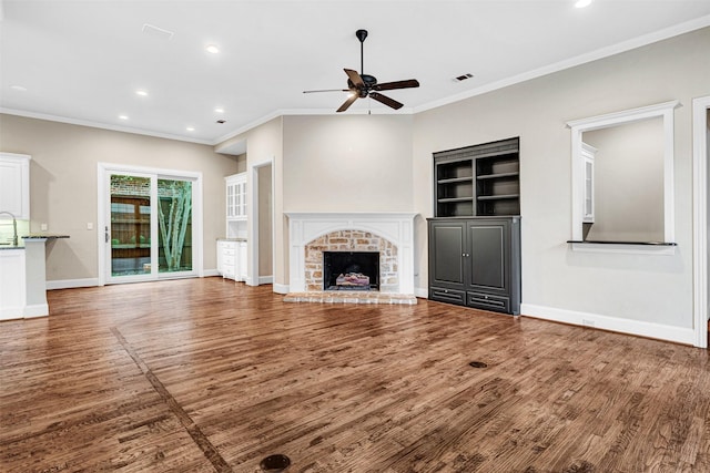 unfurnished living room featuring a brick fireplace, baseboards, ceiling fan, and wood finished floors