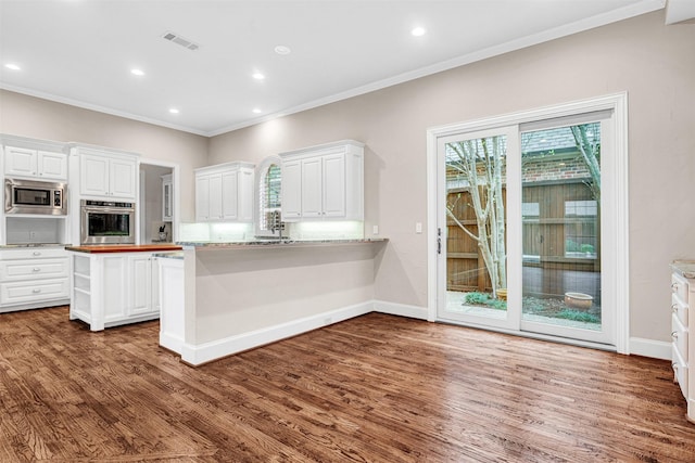 kitchen with white cabinetry, visible vents, and stainless steel appliances