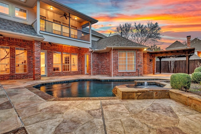 pool at dusk featuring a fenced in pool, fence, ceiling fan, and a patio area