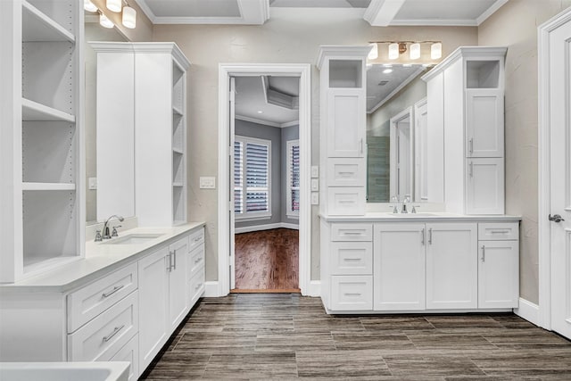 full bath featuring two vanities, ornamental molding, wood finished floors, and a sink