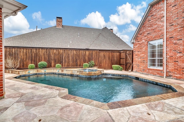 view of pool with a patio, a pool with connected hot tub, and fence