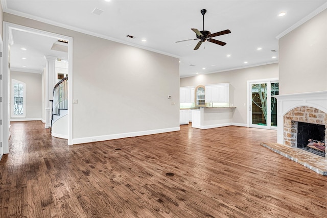 unfurnished living room with visible vents, wood finished floors, baseboards, and ceiling fan