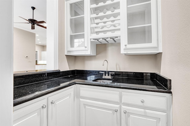 kitchen with a sink, glass insert cabinets, and white cabinetry