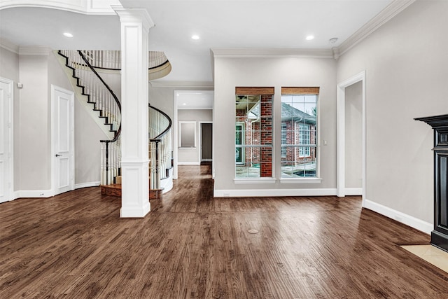 foyer featuring baseboards, wood finished floors, stairs, and ornamental molding