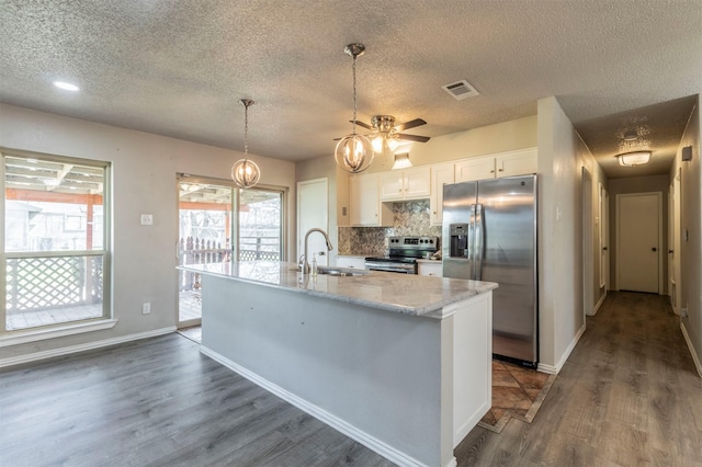 kitchen featuring visible vents, backsplash, appliances with stainless steel finishes, white cabinetry, and a sink