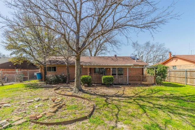 rear view of house with a yard, a fenced backyard, and brick siding