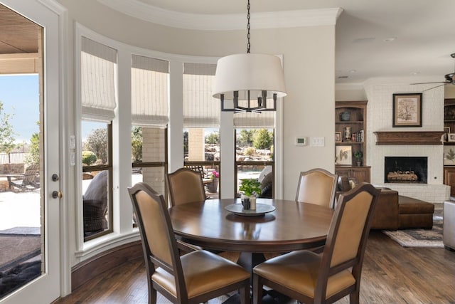 156 Stoneleigh Dr, Heath, TX 75032 - dining room with ceiling fan, dark wood-style flooring, crown molding, and a brick fireplace