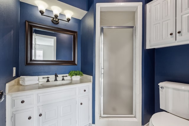 bathroom featuring vanity, toilet, and a shower stall