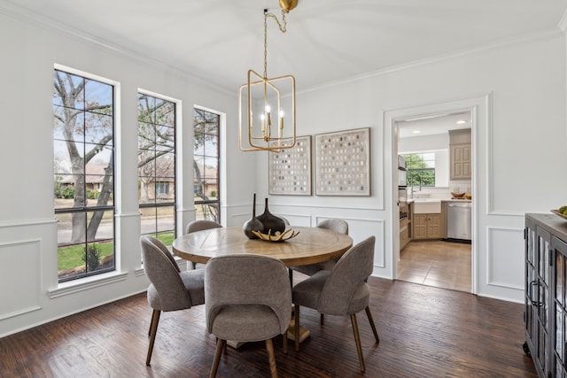 dining room with crown molding, a decorative wall, dark wood-style flooring, and a chandelier