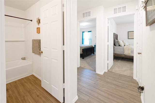 ensuite bathroom featuring visible vents, wood finished floors, and connected bathroom
