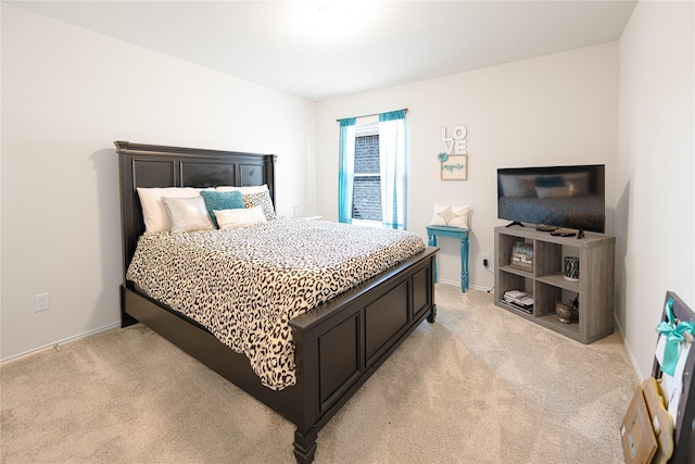bedroom featuring light carpet and baseboards