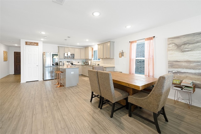 dining room featuring light wood-style flooring, plenty of natural light, recessed lighting, and baseboards