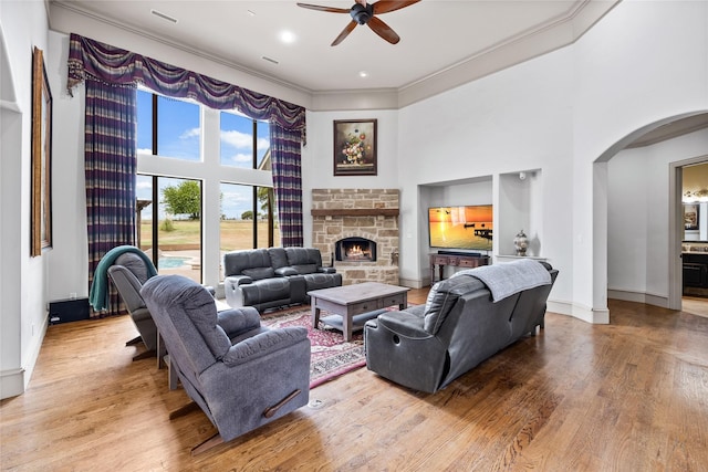 2933 N Star Dr, Celina, TX 75009 - living room featuring arched walkways, a high ceiling, wood finished floors, and a ceiling fan