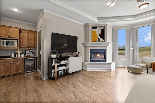 2933 N Star Dr, Celina, TX 75009 - living area featuring wood finished floors, beverage cooler, a warm lit fireplace, and ornamental molding