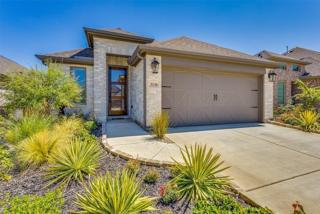 3136 Brazoria Dr, Little Elm, TX 75068 - prairie-style home featuring concrete driveway, a shingled roof, a garage, and stone siding