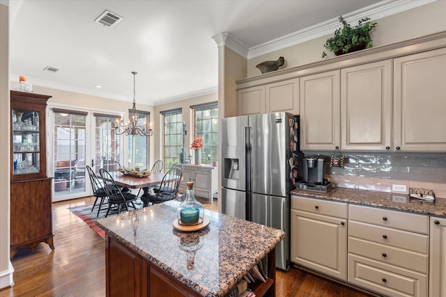 kitchen with visible vents, dark wood-type flooring, crown molding, stainless steel fridge, and a chandelier