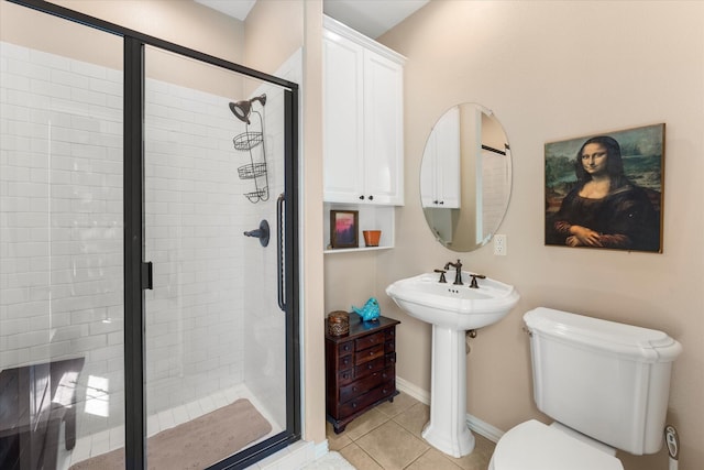 full bathroom with tile patterned flooring, a shower stall, baseboards, toilet, and a sink