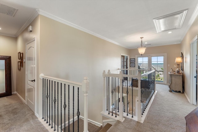 hallway featuring an upstairs landing, attic access, crown molding, and carpet floors