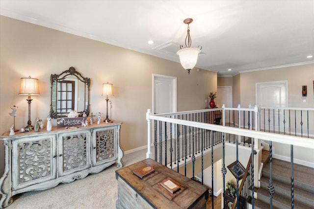 corridor with carpet, baseboards, attic access, ornamental molding, and an upstairs landing