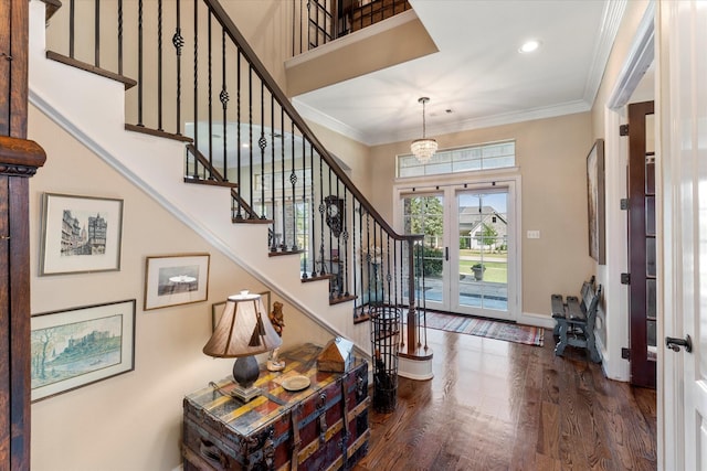 foyer entrance with stairway, wood finished floors, baseboards, and ornamental molding