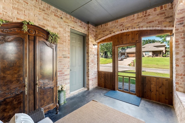 interior space featuring brick wall and concrete flooring