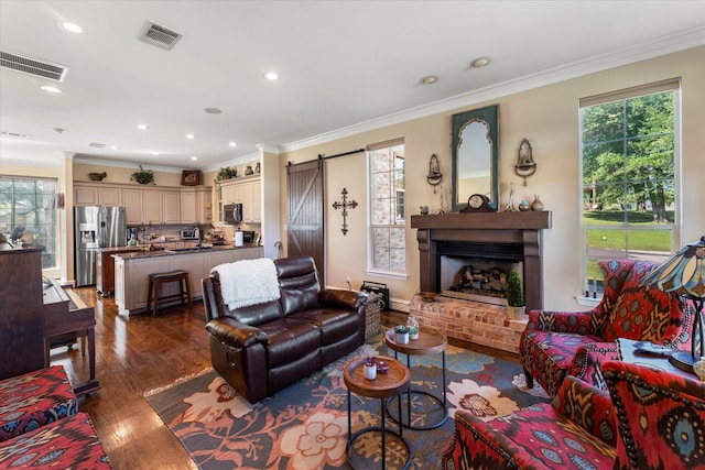 living area with dark wood finished floors, crown molding, and visible vents