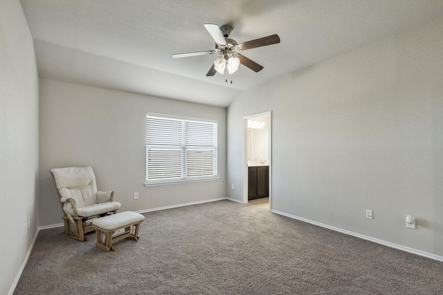 living area featuring lofted ceiling, carpet flooring, a ceiling fan, and baseboards