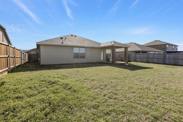 back of property featuring a fenced backyard and a yard