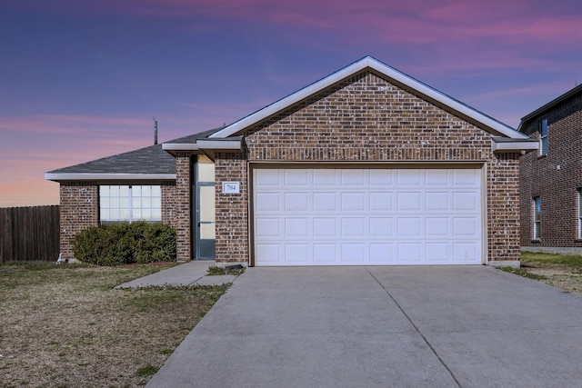 ranch-style home with driveway, fence, brick siding, a garage, and a yard