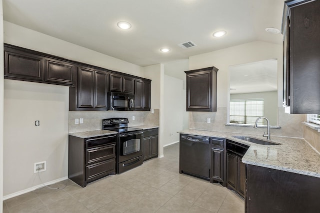 kitchen featuring light stone counters, tasteful backsplash, a sink, black appliances, and light tile patterned floors