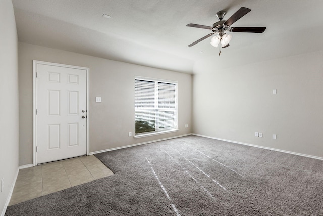 tiled entrance foyer with ceiling fan, baseboards, and carpet flooring