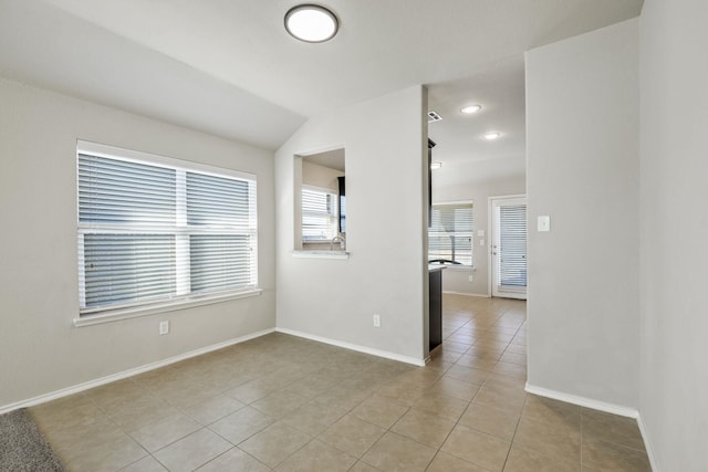 spare room featuring baseboards and light tile patterned floors
