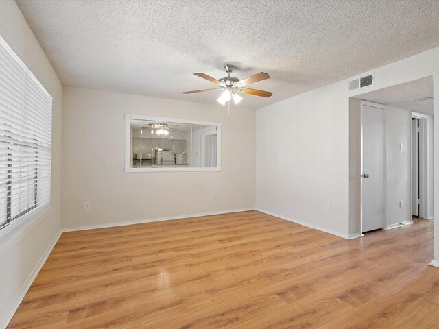 218 N Texas Blvd Unit 316, Denton, TX 76201 - empty room featuring visible vents, baseboards, light wood-type flooring, a textured ceiling, and a ceiling fan