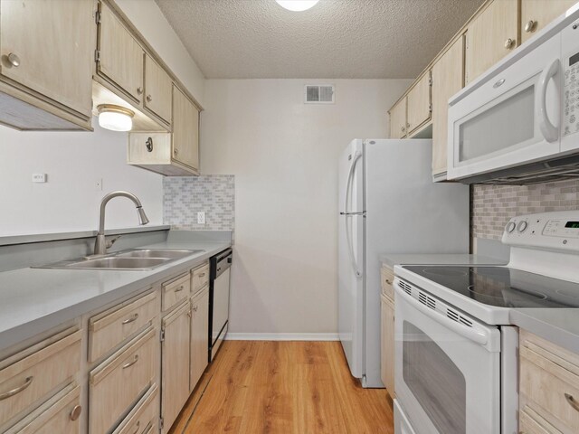 218 N Texas Blvd Unit 316, Denton, TX 76201 - kitchen featuring white appliances, light wood finished floors, a sink, light brown cabinetry, and light countertops
