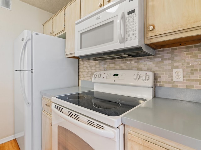 218 N Texas Blvd Unit 316, Denton, TX 76201 - kitchen featuring white appliances, light brown cabinets, visible vents, light countertops, and tasteful backsplash