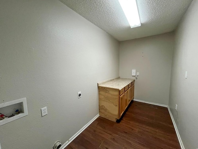 clothes washing area featuring hookup for a washing machine, hookup for an electric dryer, cabinet space, dark wood-style flooring, and a textured ceiling