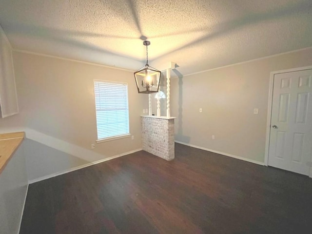 unfurnished dining area with baseboards, a notable chandelier, dark wood-style floors, and a textured ceiling