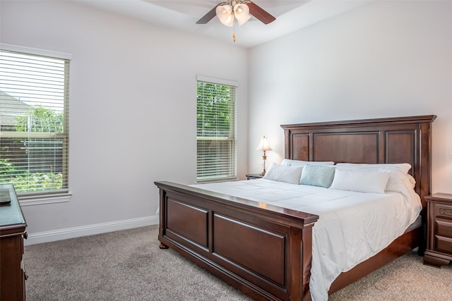 bedroom with a ceiling fan, baseboards, and light carpet