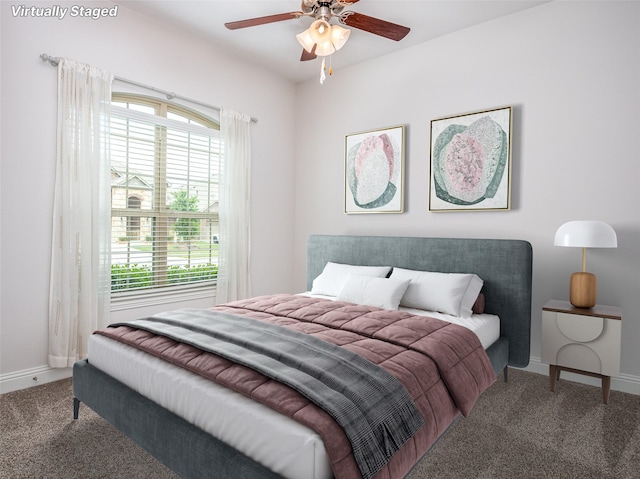 carpeted bedroom featuring baseboards, multiple windows, and ceiling fan