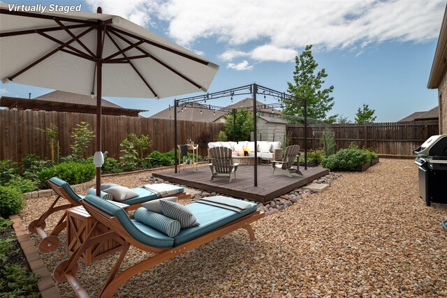 view of patio with an outdoor living space, a fenced backyard, a wooden deck, and area for grilling