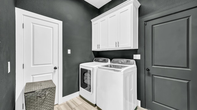 laundry room with baseboards, cabinet space, and washing machine and clothes dryer