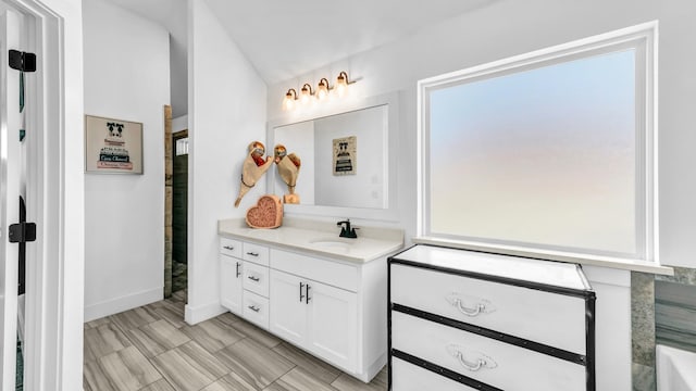 full bath with baseboards, walk in shower, plenty of natural light, and vanity