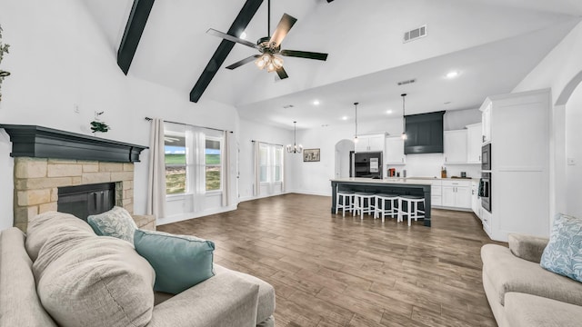 living room featuring visible vents, recessed lighting, wood finished floors, high vaulted ceiling, and ceiling fan with notable chandelier