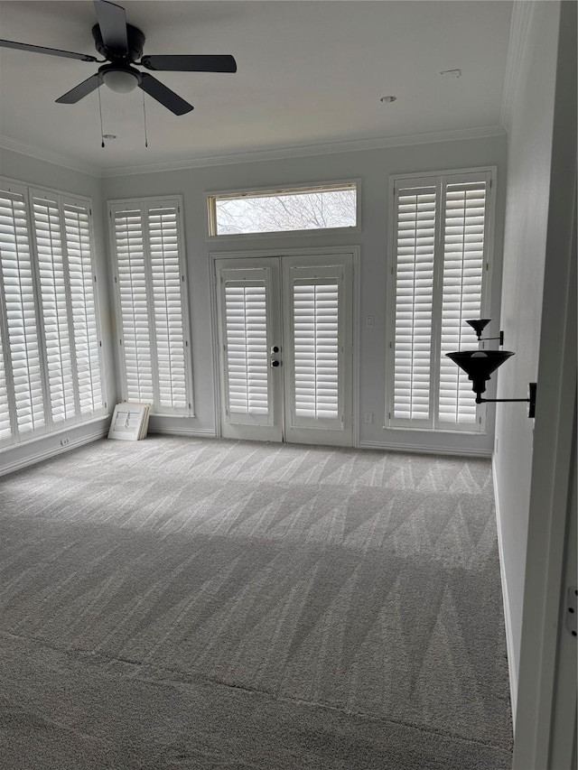 interior space featuring ornamental molding, carpet flooring, ceiling fan, and a wealth of natural light