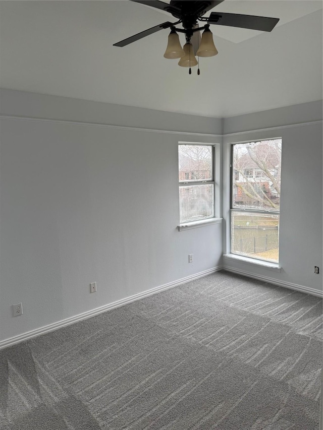 empty room featuring ceiling fan, baseboards, and carpet floors