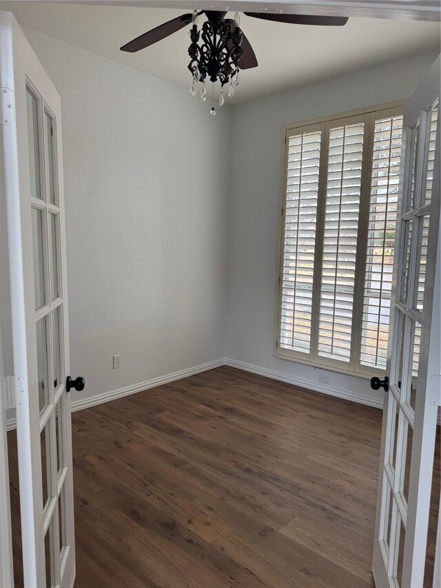 spare room with dark wood-style floors, a ceiling fan, french doors, and baseboards